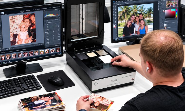 A Forever Studios technician scanning family photographs at the flatbed bench