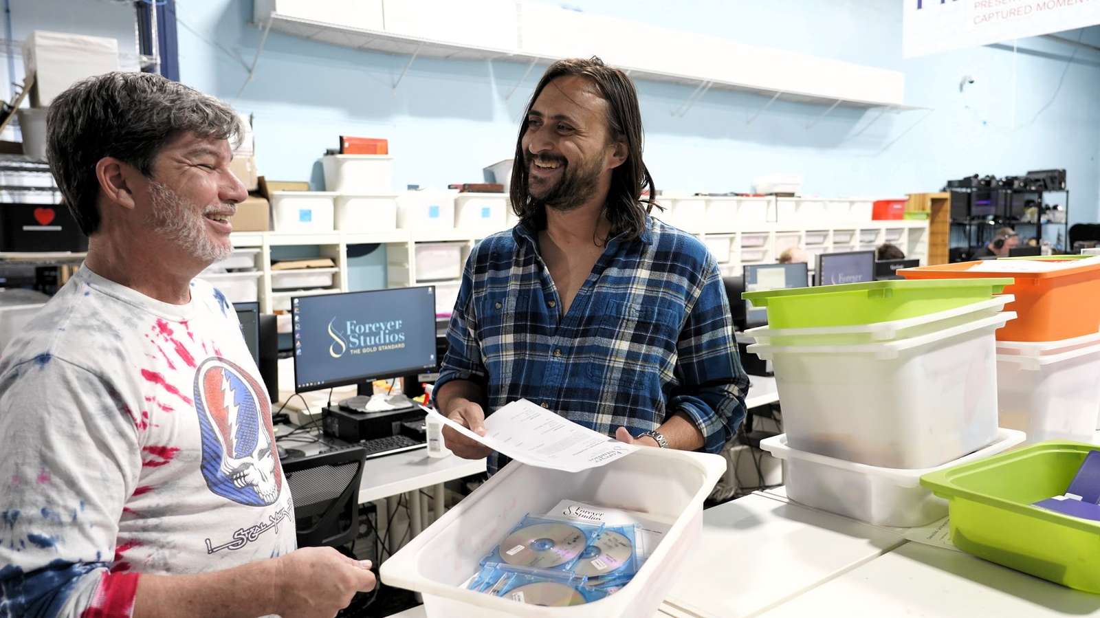 A customer handing a bin of media across the counter at the Forever Studios studio