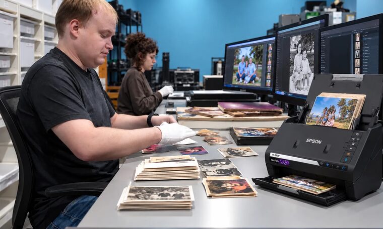 Forever Studios technicians sorting and scanning stacks of family photographs