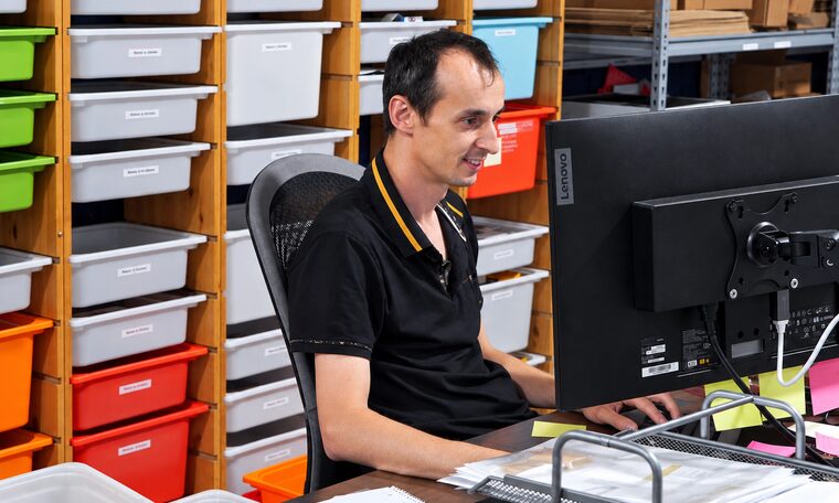 A Forever Studios staff member logging orders at the intake desk