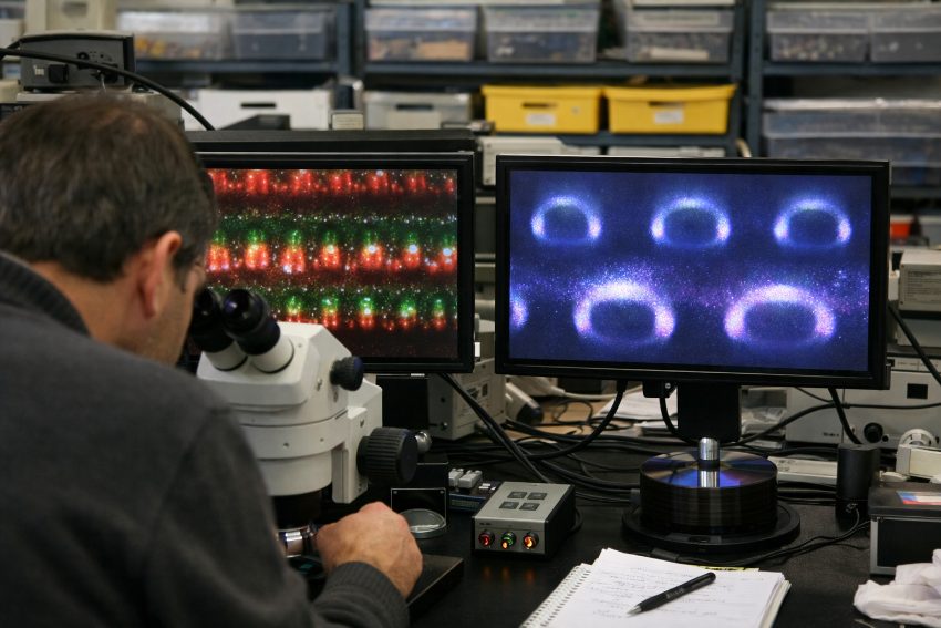 side-by-side comparison of DVD and CD pit spacing under magnification with measurement annotations