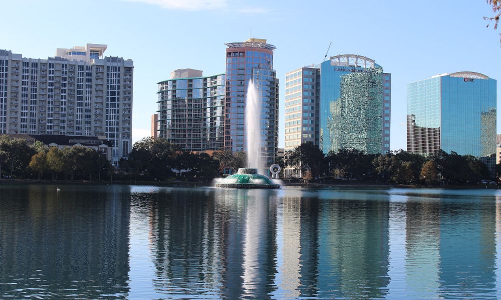 The fountain at Lake Eola with the downtown Orlando skyline reflected in the water behind it