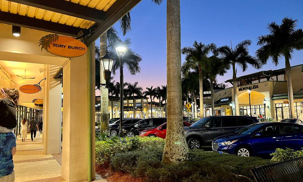 Storefronts and palm trees at the Colonnade Outlets at Sawgrass Mills in Sunrise, Florida, at dusk
