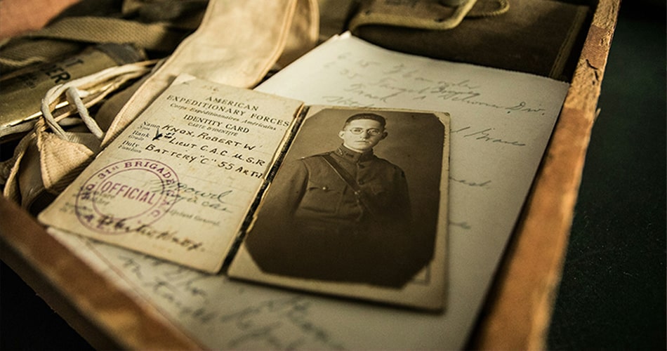 Faded sepia-tone family photograph showing dust particles and age-related emulsion cracks